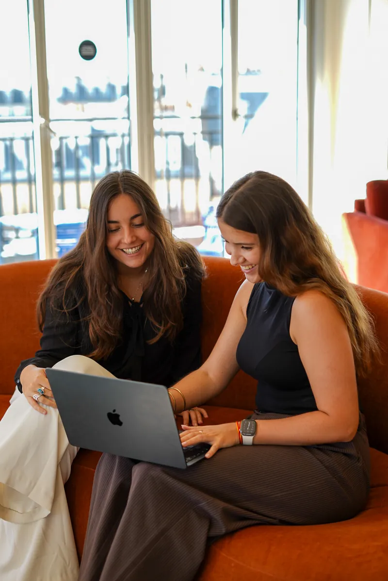 Two Licter consultants going through a collection on a laptop, on a sofa